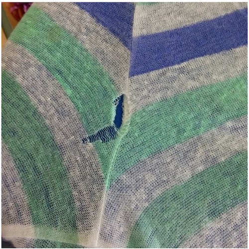 Beschädigte Strickkleidung vor dem Kunststopfen